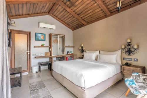 a bedroom with a large white bed and a window at The Baga Beach Resort in Baga