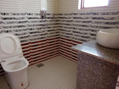 uma casa de banho com um WC e um lavatório em Hotel Mirage Sauraha em Sauraha