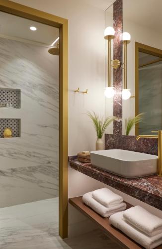 a bathroom with a tub and a sink at Orloff Legacy Suites Hydra in Hydra