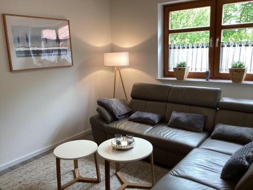 a living room with a couch and two tables at Landhaus Saterland Ferienwohnung NEU Emsland Ostfriesland Nordsee in Sedelsberg