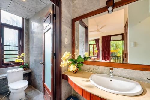a bathroom with a sink and a toilet at Hoi An Green Riverside Oasis Villa in Hoi An