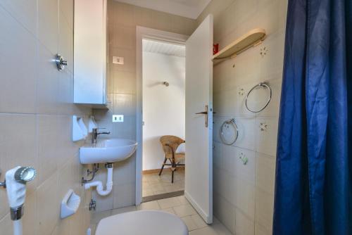 a bathroom with a toilet and a sink and a shower at Il Quadrifoglio 5 in Procchio