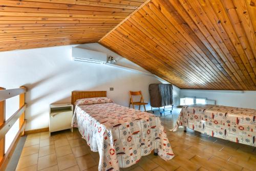 普羅基奧的住宿－Il Quadrifoglio 5，一间卧室设有两张床和木制天花板