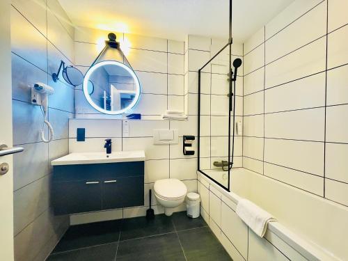 a bathroom with a sink and a toilet and a mirror at Berghotel Kristall in Idar-Oberstein