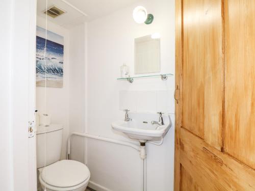 een witte badkamer met een toilet en een wastafel bij Burfield Cottage in Windsor