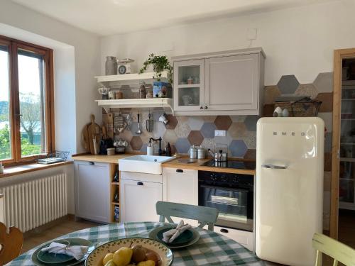 een keuken met een witte koelkast en een tafel bij B&B Antico Fienile in Gorizia