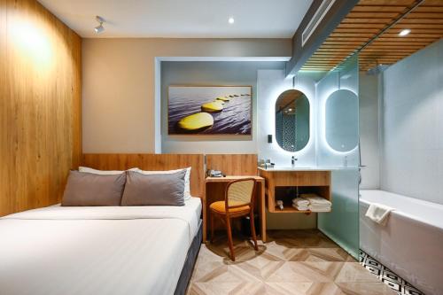 La Opera Saigon Hotel في مدينة هوشي منه: غرفة نوم بسرير وحمام مع حوض استحمام