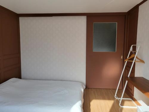 a small bedroom with a bed and a ladder at Cheukhu-dong 19street Guesthouse in Mokpo