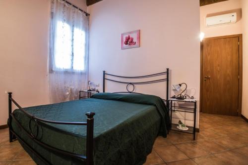 a bedroom with a bed with a green blanket and a window at Agriturismo Casetta I in Vinci