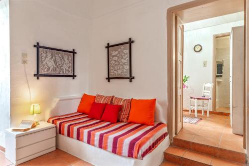 a living room with a couch with orange pillows at Apano Vrysi Tinos 4 in Tinos Town