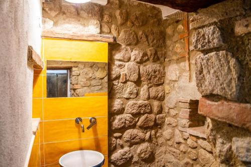 a stone bathroom with a toilet in a stone wall at La casa di Maffin in Roccastrada