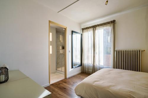 a bedroom with a bed and a large window at The Golden white, Luxury T3 in Annecy