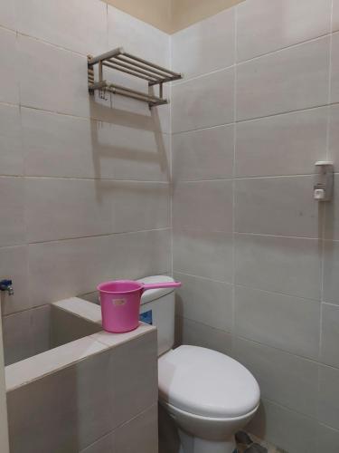 a bathroom with a toilet and a pink bucket at Penginapan Sriwijaya Semarang in Jomblang