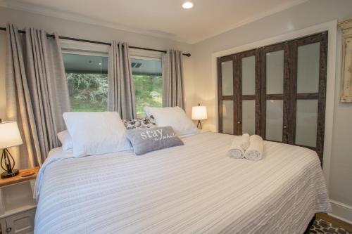 a bedroom with a white bed with two slippers on it at Eagles Nest on Seven Devils in Seven Devils