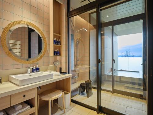 a bathroom with a sink and a shower at Lake Toya Tsuruga Resort HIKARINOUTA in Lake Toya