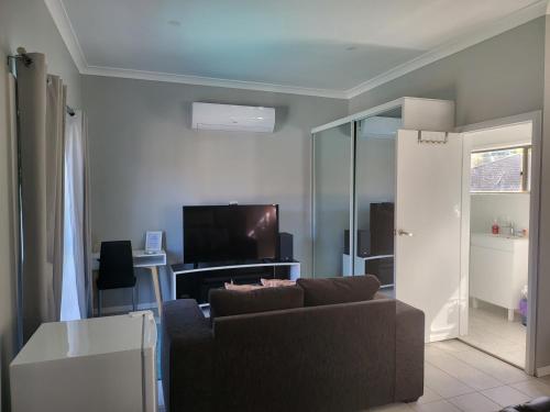 a living room with a couch and a tv at T&V Suites in Windsor