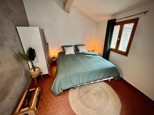 une chambre avec un lit avec une couette verte dans l'établissement Charmant appartement, à Bédoin