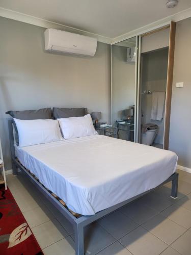 a bed in a room with a large white bed at T&V Suites in Windsor