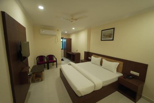 MuthiganjにあるICON PALACE INNのベッドとテレビ付きのホテルルーム