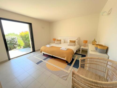 une chambre avec un lit et une grande fenêtre dans l'établissement Villa A Muredda, à Sainte-Lucie de Porto-Vecchio