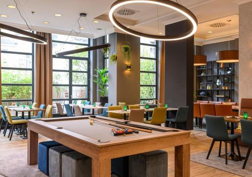 a pool table in a room with tables and chairs at Holiday Inn Brussels Schuman, an IHG Hotel in Brussels