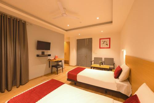 a hotel room with two beds and a television at The Grand Tashree at Delhi Airport in New Delhi