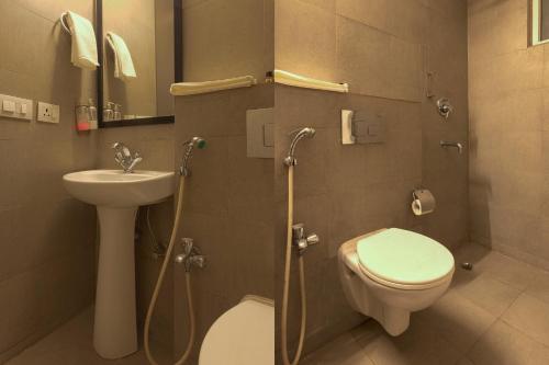 a bathroom with a toilet and a sink and a shower at The Grand Tashree at Delhi Airport in New Delhi