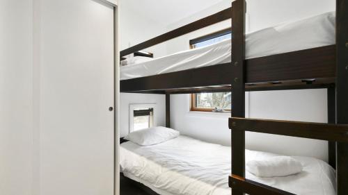a bedroom with two bunk beds and a mirror at Dandongale in Dinner Plain