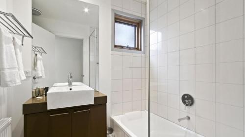 a white bathroom with a sink and a shower at Dandongale in Dinner Plain