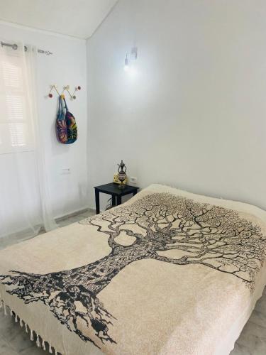 a bed with a tree design on it in a bedroom at Dar zmen 
