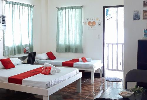 a room with two beds and a window at RedDoorz Bunakidz Lodge El Nido Palawan in El Nido
