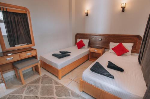 a small room with two beds and a mirror at Swiss Royal DAHAB in Dahab