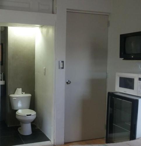 a bathroom with a toilet and a microwave at Dams house 