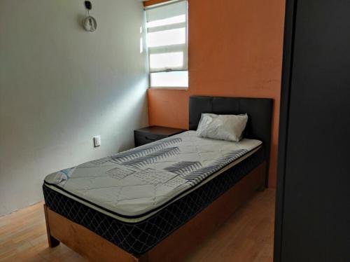 uma pequena cama num quarto com uma janela em Dams house 