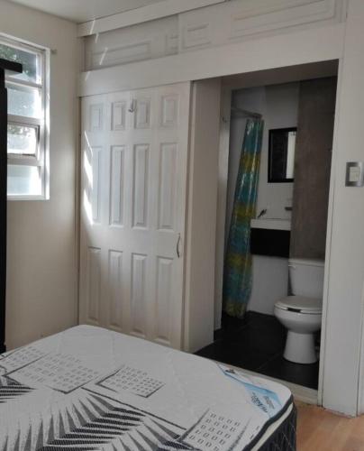 um quarto com uma cama e uma casa de banho com um WC em Dams house 