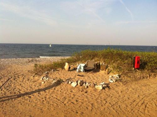 a campsite on a sandy beach next to the ocean at Strand & Garten in Surendorf