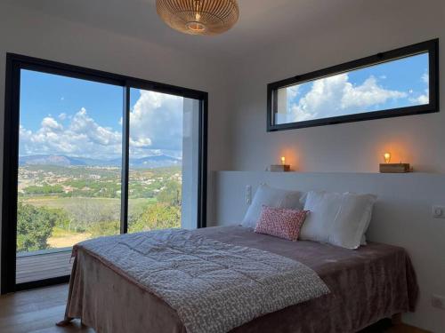 um quarto com uma cama e 2 janelas grandes em Villa Alandra em Pietrosella