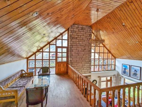 a large room with a wooden ceiling and a table at Harippur Cottages and Resort - Manali in Manāli