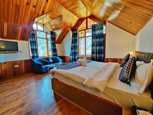 a bedroom with a large bed in a room with wooden ceilings at Harippur Cottages and Resort - Manali in Manāli