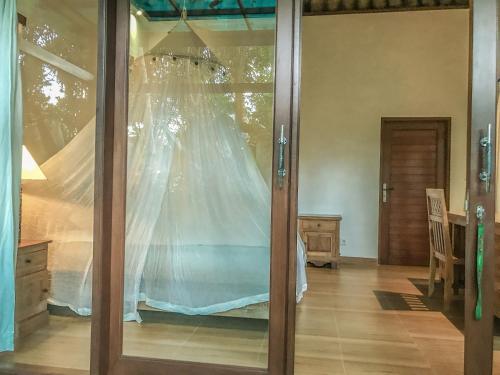 una camera con letto e rete di Cozy Wayan Sueta's Garden Villa 2 ad Ubud
