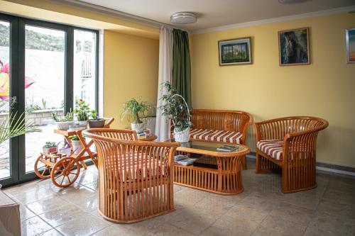 a living room with wicker chairs and a table at Apart-hotel Villa Lav in Tivat