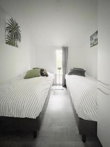 two beds sitting next to each other in a bedroom at Beachhouse Veluwemeer mit großem Garten in Strandnähe (inkl. Hallenbadnutzung) in Hulshorst