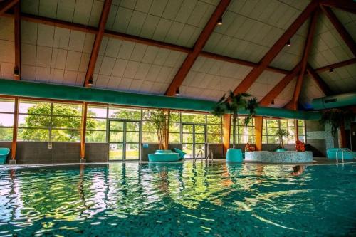a large swimming pool with a large amount of water at Beachhouse Veluwemeer mit großem Garten in Strandnähe (inkl. Hallenbadnutzung) in Hulshorst