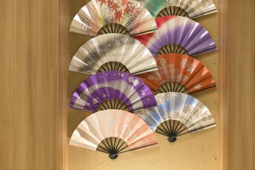 a bunch of colorful umbrellas hanging on a wall at Fujisan Station Hotel in Fujiyoshida