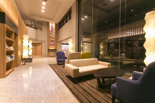 a lobby with couches and a table and chairs at Fujisan Station Hotel in Fujiyoshida