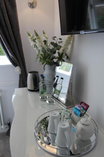 a white table with a glass tray and cups on it at The Mount Pleasant Hotel in Sidmouth