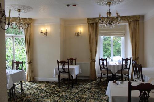 a dining room with tables and chairs and windows at The Mount Pleasant Hotel in Sidmouth