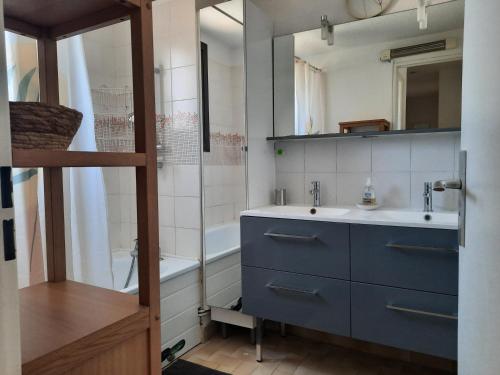 La salle de bains est pourvue d'une armoire bleue et d'un lavabo. dans l'établissement Résidence les Sables D'or, au Cap d'Agde
