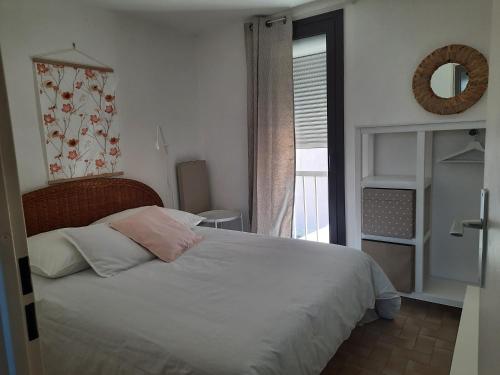 une chambre avec un lit blanc et une fenêtre dans l'établissement Résidence les Sables D'or, au Cap d'Agde