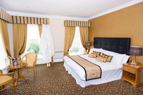 a bedroom with a large bed and a table and chairs at Towers Hotel Glenbeigh in Glenbeigh